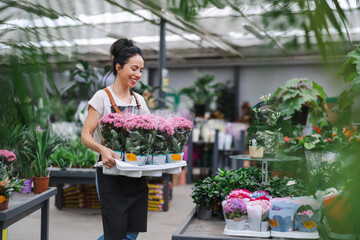 Shot of a young woman working with plants in a garden centre