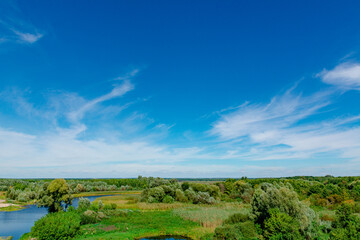 A beautiful landscape: a view of a green valley and a river, a beautiful blue sky above nature. Nature of Ukraine photo.