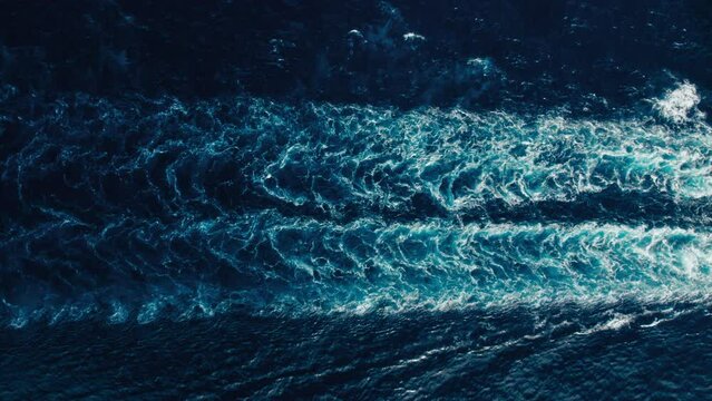 Traces of big nautical vessel on blue ocean water. Huge cruiser ship leaves water trace in sea.