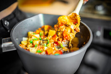 Woman cooking tasty vegetable stew in pan on kitchen