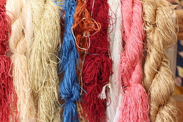 Hanging bundles of raw silk threads in different colors, colorful silk threads, rainbow concept, front view of colorful ropes in bursa