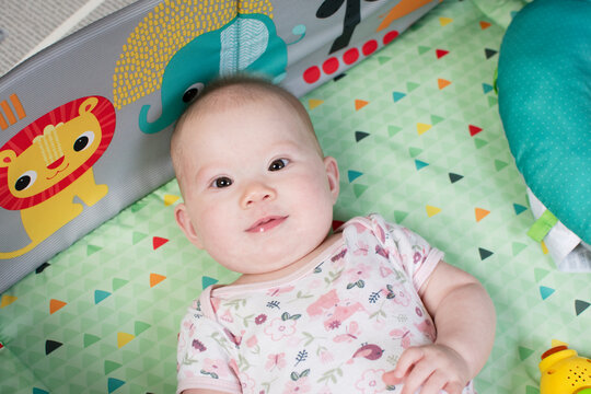 Cute caucasian baby girl on the play mat. Baby's first year