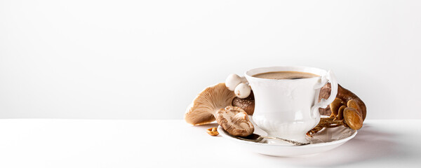 Mushroom coffee in white porcelain vintage cup over white background. New Superfood Trend. Copy...