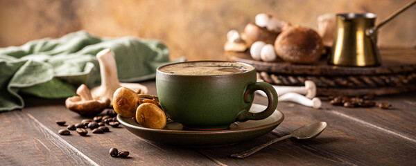 Banner with mushroom coffee in green cup on wooden background. New Superfood trendy healthy concept...