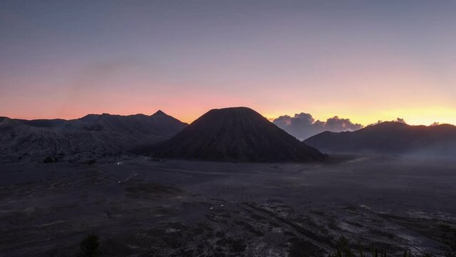 Beautiful sunset over active volcano Bromo mountain with car driving in Bromo Tengger Semeru National Park, East Java, Indonesia