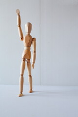 Greeting or leadership concept represented in a wooden doll	