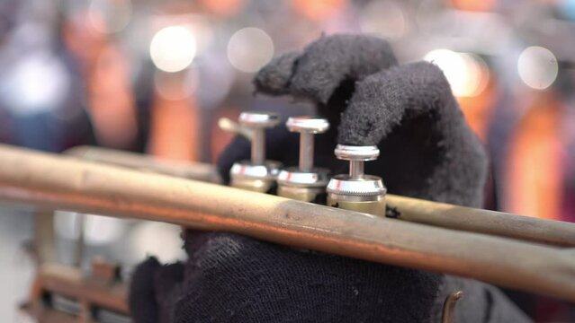 People blowing trumpets in marching band on blurred background