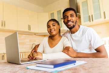 Obraz premium young couple sitting with laptop and education online at kitchen at home