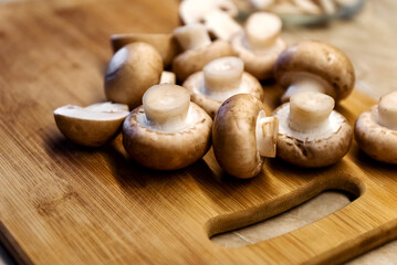 Fresh champignons mushrooms on wooden cutting board
