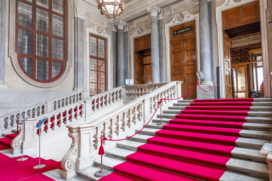 Turin, Italy - Circa January 2022: red carpet in Royal Palace - luxury elegant marble stairway.