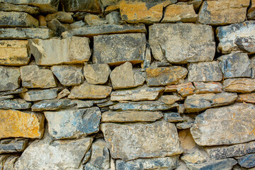 Stone antique old wall as a background or texture. Vintage background of a fortress wall in loft and grunge style with place for text and copy space.