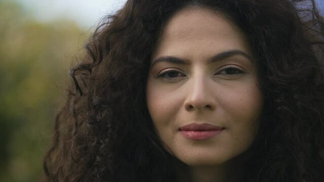 One hispanic latina woman closeup face looking at camera. South American famel person with serious expression