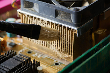 Cleaning dirty desktop computer processor fan from dust by special brush close up.