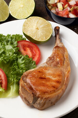 Grilled pork rib with salad and vinaigrette.