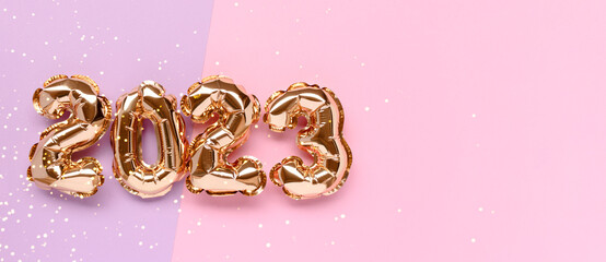 Banner with 2023 gold inflatable balloons on a pink and purple background with place for text. New...