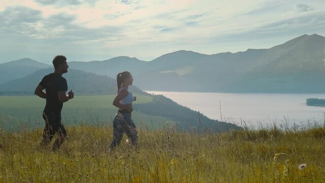 The man and woman jogging on the beautiful river background. slow motion