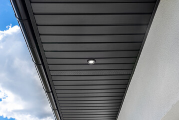 A modern graphite roof lining is attached to the trusses, visible turned on LED lights.