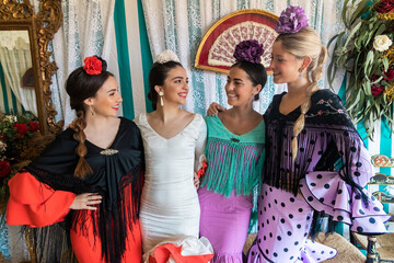 Positive Hispanic women in flamenco dresses in tent - obrazy, fototapety, plakaty