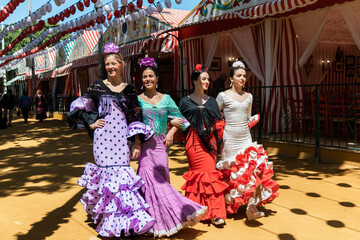 Young Hispanic women in flamenco dresses in city - obrazy, fototapety, plakaty