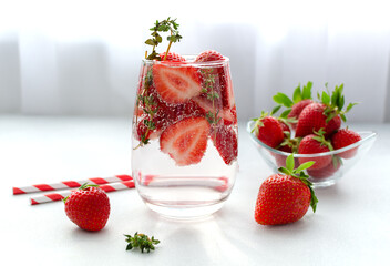 Detox strawberry thyme infused water or mocktail in a glass on white background