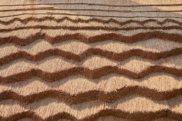 Fototapeta na wymiar Beautiful thatched roof with original wave pattern.