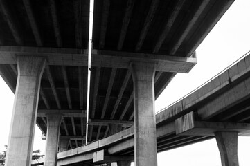 Black and white photo of architecture lines under the bridge