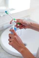 Woman hands holding toothpaste and toothbrush