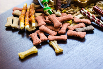 Dog colored biscuits on wooden background, snacks for dogs.