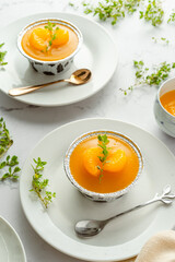 orange cake topping with orange jam decorate with lemon thyme on the white backdrop