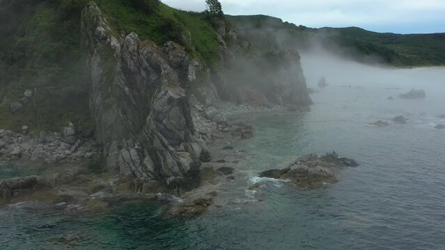 Rocky coastline with fogs in Primorye, Russia.