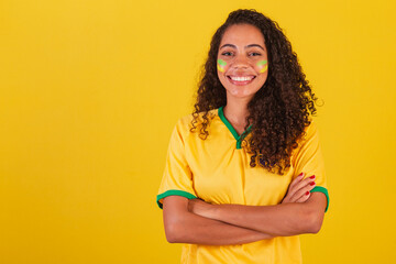 Young black Brazilian woman, soccer fan. arms crossed over the body.
