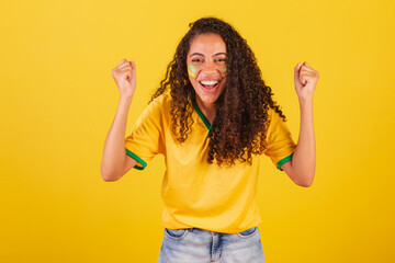 Young black Brazilian woman, soccer fan. celebrating and celebrating.