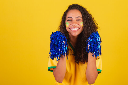 Young black Brazilian woman, soccer fan. holding cheerleader pom poms. close-up photo