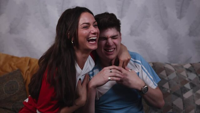 Rival fans watch football together female reds fan gloating in close up