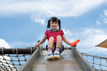 Little girl playing on the slider, Little pretty girl is having fun outdoor , happy preschool...