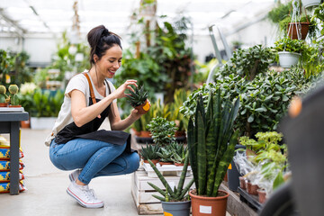 Shot of a young woman working with plants in a garden centre
