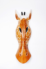 Wooden souvenir giraffe head on a white background.African animal mask for wall decoration.Vertical...