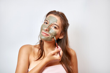 The girl uses blue clay for face care. Beauty concept, skin care cosmetics, facelift. Beauty salon. Wrinkle removal.