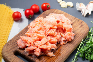 chopped pieces of raw salmon on a cutting board.
