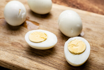 Halves of boiled chicken eggs on a wooden background.