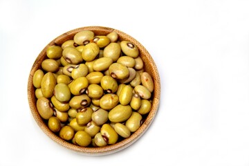 Yellow Ball Beans (Phaseolus vulgaris) in a wooden bowl, isolated, top view on a white background.