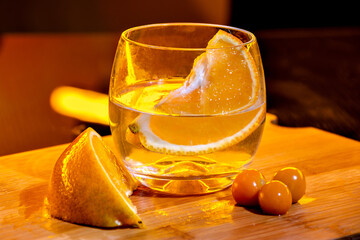 orange cocktail. alcoholic drink with fried orange. drink served in bar. led lights decorating...