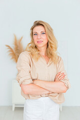 beautiful slender woman with blonde hair, stands in white interior