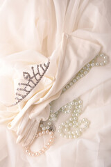 crown gloves and pearls on white silk