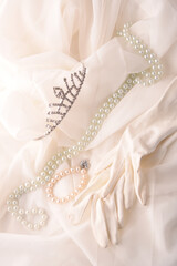 crown gloves and pearls on white