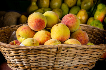 peaches in a basket. sale of sweet fruit in the market place. group of peaches. tropical fruits. sweet fruits in a basket.  
