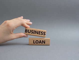 Business loan symbol. Concept words business loan on wooden blocks. Beautiful grey background. Businessman hand. Business and business loan concept. Copy space.