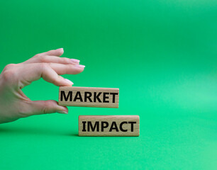 Market impact. Concept word Market impact on wooden cubes. Beautiful green background. Businessman hand. Business and Market impact concept. Copy space.