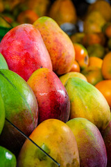 large mangoes. mangoes for sale in the market place. latin american market place. mangoes group. sweet fruits. 