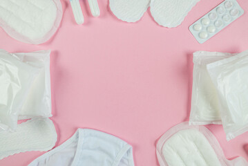 pads, tampons, panties, pills on a pink background with copy space.